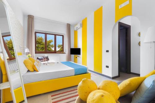 Dormitorio amarillo y blanco con cama y sofá en Sorrento Home, en Sorrento