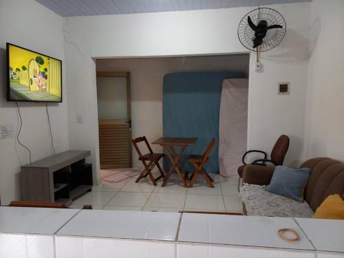 Casa bom espaço para passar suas férias في ماتينيوس: غرفة معيشة مع أريكة وطاولة ومروحة