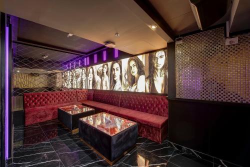 a red couch in a room with pictures on the wall at Wescott Hotel in Dubai