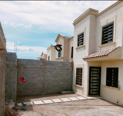 una casa que se está construyendo con una pared de retención en Mazahouse, en Isla de la Piedra