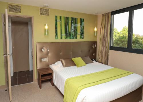 1 dormitorio con 1 cama grande en una habitación en Hotel Le Quercy - Sure Hotel Collection by Best Western, en Brive-la-Gaillarde