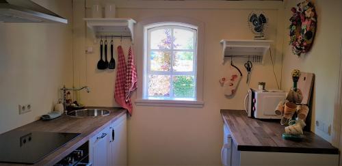 uma cozinha com um lavatório e uma janela em B&B Farmhouse De Loksheuvel em Overasselt