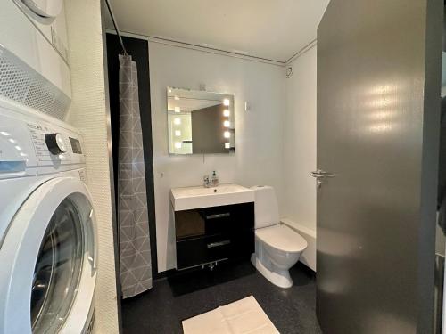 een badkamer met een wastafel, een toilet en een wasmachine bij Apartment in Torshavn in Tórshavn