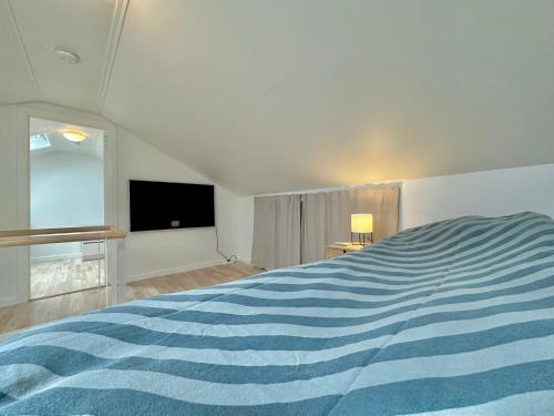 een slaapkamer met een blauw en wit gestreept bed bij Apartment in Torshavn in Tórshavn