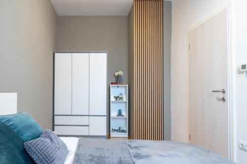 a bedroom with a bed and a book shelf at Old Town's Legend: City center condo with balcony in Maribor