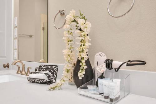 un baño con un jarrón con flores en una encimera en Beautiful Luxurious Houston Galleria Home en Houston