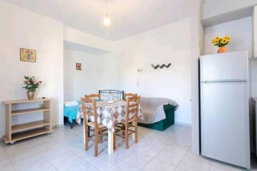 a dining room with a table and a refrigerator at SUN Studio Pitsidia-Matala in Pitsidia