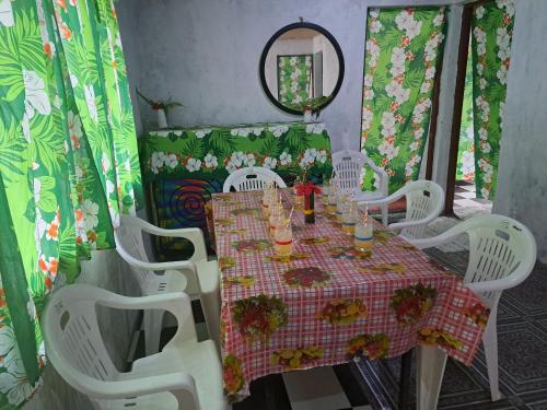 a table with white chairs and a table and a mirror at Appartement de Charles in Loméméti