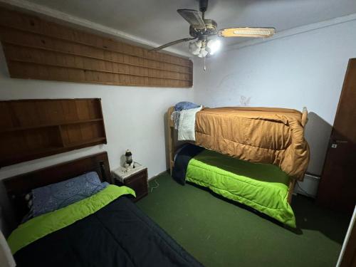 twee bedden in een kamer met groene lakens bij Habitaciones Individuales Boulogne in Boulogne
