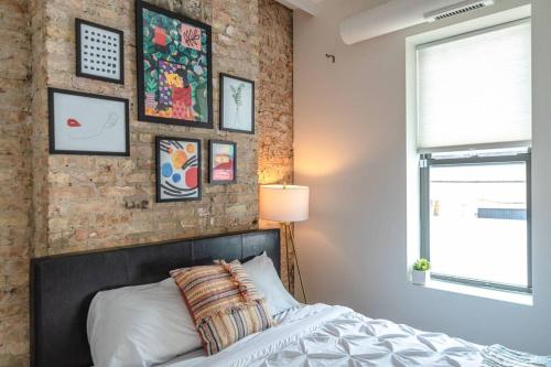 a bedroom with a bed and a brick wall at McCormick Place 420 friendly 3Br Family Unit for up to 8 guests with optional parking in Chicago