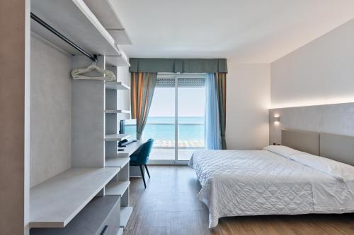 1 dormitorio con cama y vistas al océano en Hotel Columbus en Lignano Sabbiadoro