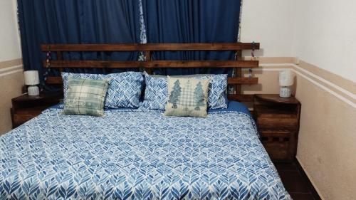 1 dormitorio con 1 cama con sábanas y almohadas azules en Departamento Céntrico y cerca del Foro Sol en Ciudad de México