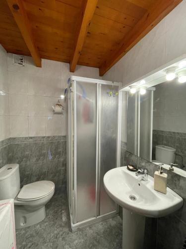 y baño con ducha, aseo y lavamanos. en El escondite de Torazo, en Torazo