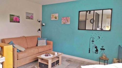 uma sala de estar com um sofá e um espelho em a lovely nest em Bussy-Saint-Georges