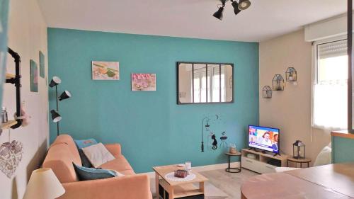 a living room with a couch and a tv at a lovely nest in Bussy-Saint-Georges