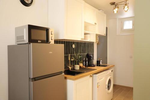 une cuisine avec un réfrigérateur et un micro-ondes dans l'établissement Appartement 2 pièces au Raincy proche de PARIS, à Le Raincy