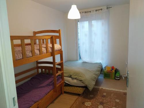 a bedroom with two bunk beds and a window at BIG logement , Stade de France à pied, PARIS, métro , parking gratuit in Saint-Denis