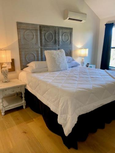 a large bed in a bedroom with two lamps at City on a Hill at Spring Creek in Fredericksburg