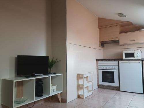 uma sala de estar com uma televisão e uma cozinha em Ático en Carril con vistas al mar em Vilagarcía de Arousa