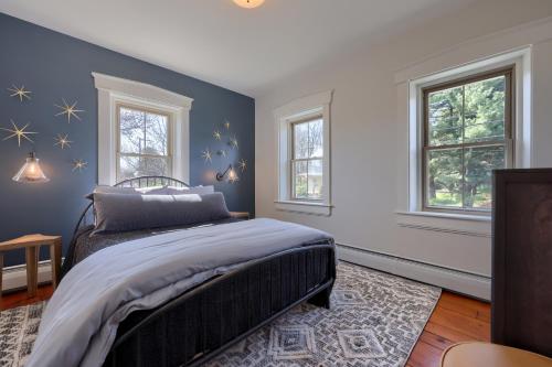 a bedroom with a bed with blue walls and windows at The Tannery in Lancaster