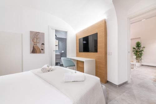 a bedroom with a bed and a desk and a tv at Casa Spada Rooms in Cagliari