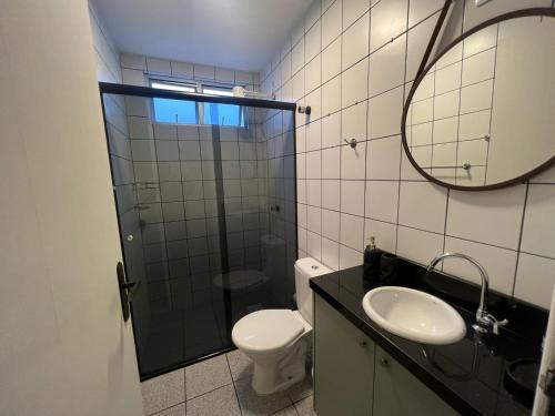 a bathroom with a toilet and a sink and a mirror at BETARA in Florianópolis
