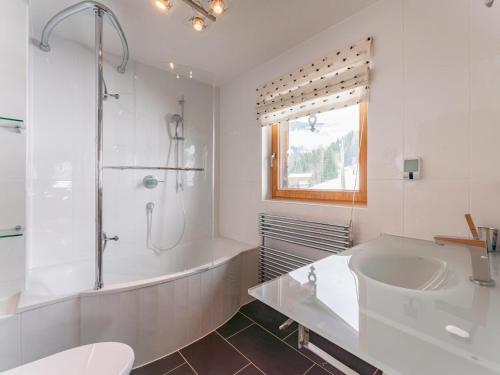 a white bathroom with a tub and a sink at Chalet Mountain View in Alpbach