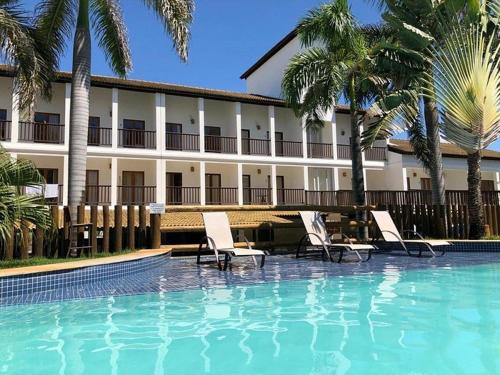 un hotel con una piscina con sillas y un edificio en Tree Bies en Subaúma