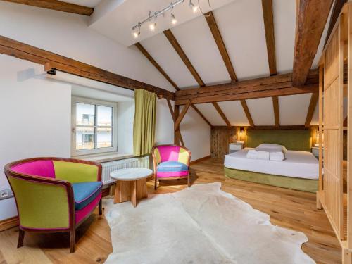 a bedroom with a bed and two chairs at Biber Art Apartment 1 in Biberwier