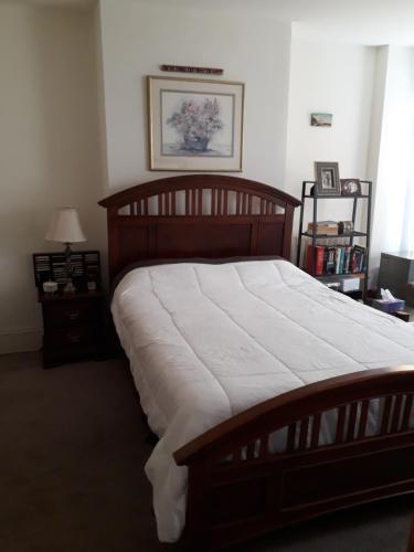 a bedroom with a large wooden bed with white sheets at Pleasant Rooming House in Washington