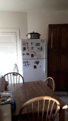a kitchen with a table and a white refrigerator at Pleasant Rooming House in Washington