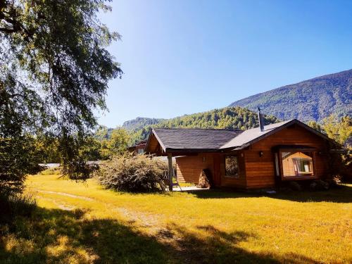 una cabaña de madera en medio de un campo en Cabañas Santa Maria Huife, en Pucón