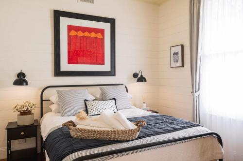 a bedroom with a bed with a basket on it at Benambra Cottage - Pet Friendly in Queenscliff