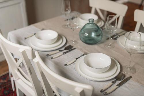 einen Esstisch mit weißen Tellern und Besteck in der Unterkunft Benambra Cottage c1860 - PET FRIENDLY in Queenscliff