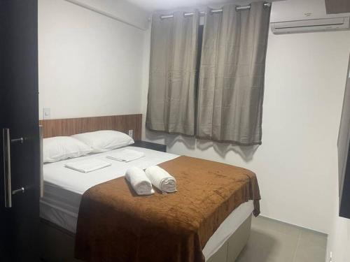 um quarto com uma cama com duas toalhas em Apartamento em Ponta Verde em Maceió