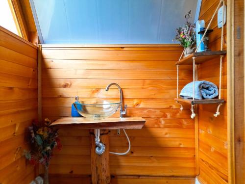 a bathroom with a sink in a wooden wall at Dante Glamping in Guatavita