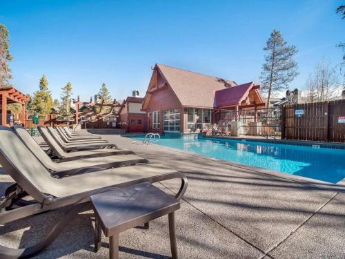 uma fila de espreguiçadeiras junto a uma piscina em 2BR 2BA Pine Ridge Condo, Ski In em Breckenridge