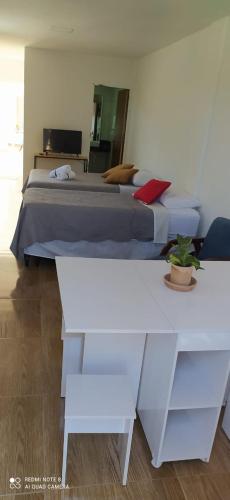 ein Schlafzimmer mit einem Bett und zwei weißen Tischen in der Unterkunft Quarto Família - Com Suíte in Baía Formosa