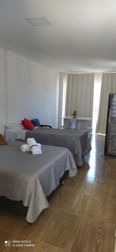 1 dormitorio con 2 camas y suelo de madera en Quarto Família - Com Suíte en Baía Formosa