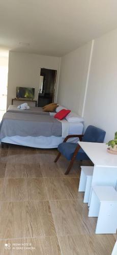 sypialnia z dużym łóżkiem i stołem w obiekcie Quarto Família - Com Suíte w mieście Baía Formosa