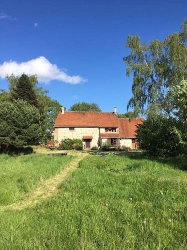 une maison dans un champ d'herbe avec un chemin de terre dans l'établissement Maison familiale de campagne - 10 personnes, à Le Vézier