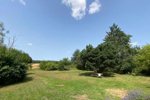 un parc avec un banc dans un champ arboré dans l'établissement Maison familiale de campagne - 10 personnes, à Le Vézier