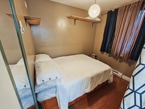 a small bedroom with a bed and a window at Downtown Whitehorse Apartment in Old Town in Whitehorse