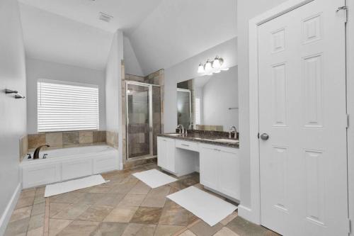 uma casa de banho branca com uma banheira e um lavatório em Dreamy 3BDRM Museum/Med ctr Gem em Houston