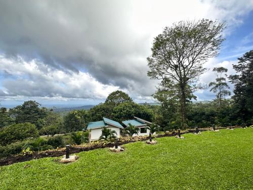 a house in the middle of a green field at Casa areno lodge in Bijagua
