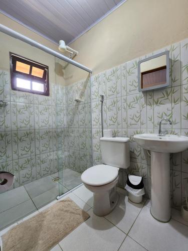 a bathroom with a toilet and a sink and a shower at Pousada Morena Raiz in Ubatuba