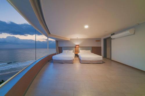 EL Hotel في يانغيانغ: سريرين في غرفة مطلة على المحيط