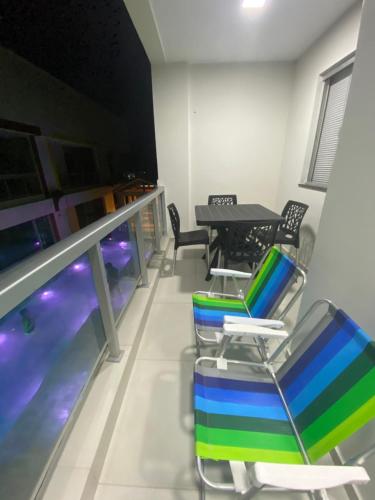 um quarto com uma piscina, uma mesa e cadeiras em Premier do Atalaia em Salinópolis
