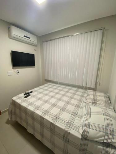 um quarto com uma cama grande e um cobertor xadrez em Premier do Atalaia em Salinópolis