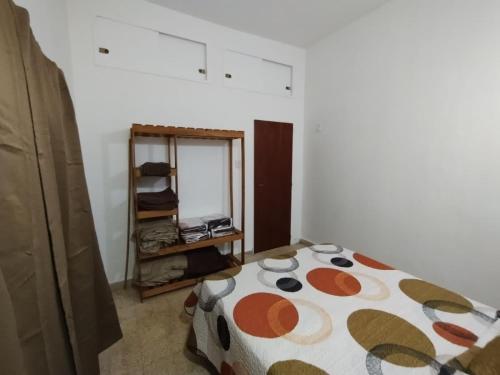 a bedroom with a bed with a comforter on it at Casa Ana2, a 20 min del aeropuerto de ezeiza in Luis Guillón